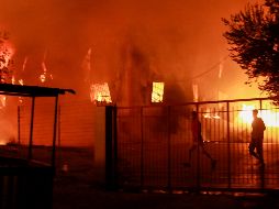 Migrantes huyen del campamento en llamas. Hasta el momento no se han reportado víctimas humanas. AFP/M. Lagoutaris