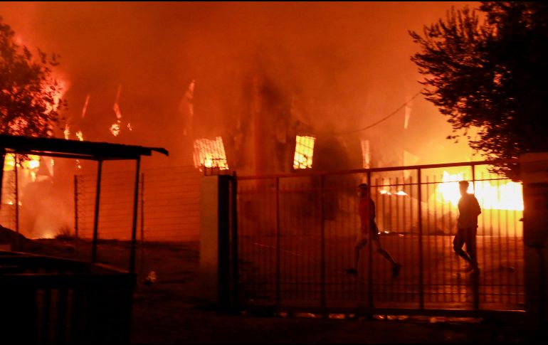 Migrantes huyen del campamento en llamas. Hasta el momento no se han reportado víctimas humanas. AFP/M. Lagoutaris