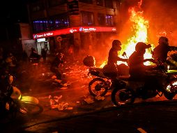 Manifestantes lanzan piedras a policías esta madrugada en Bogotá. AFP