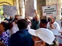 Los inconformes se agrupan en los alrededores del mercado San Juan de Dios y caminan rumbo a la presidencia municipal donde con pancartas y gritos solicitan reunirse con el alcalde Ismael del Toro. ESPECIAL