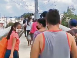 DESDE LO ALTO. Usuarios caminan a un costado de las vías, sobre el paso elevado, tras una falla técnica. ESPECIAL