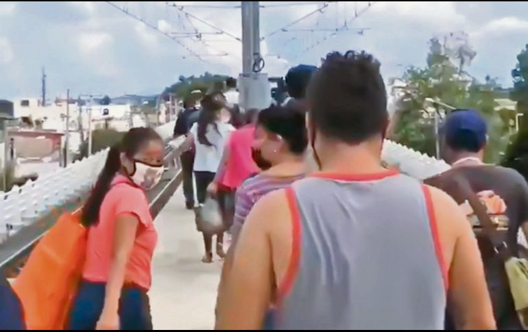 DESDE LO ALTO. Usuarios caminan a un costado de las vías, sobre el paso elevado, tras una falla técnica. ESPECIAL