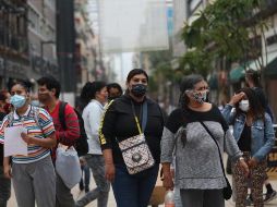 Personas usan cubrebocas para evitar el contagio con el coronavirus hoy, en una calle de la Ciudad de México. EFE/S. Gutiérrez
