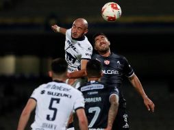 Carlos González (i) de Pumas e Ian González (d) del Necaxa saltan al cabecear el balón este sábado. EFE/J. Núñez