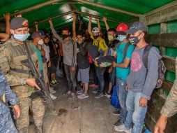 Un grupo de migrantes suben a un camión del ejército de Guatemala que los regresaría a la frontera entre Honduras y Guatemala, este sábado, en Morales. EFE/E. Biba