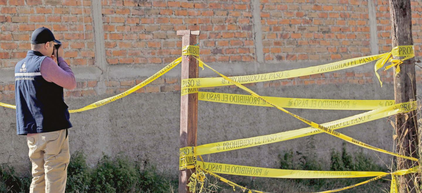 RESGUARDO.  Trabajadores del Instituto Jalisciense de Ciencias Forenses resguardan la escena de una fosa clandestina.