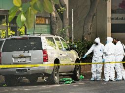 Peritos. Investigadores forenses buscan pistas del ataque a mando de la Ciudad de México. AP