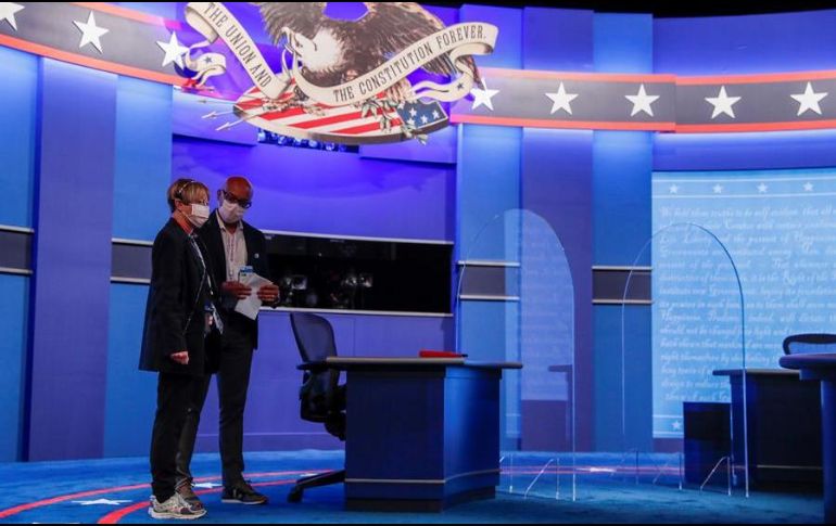 Trabajadores ultiman detalles para el debate, en el que se tomaron medidas preventivas más severas para evitar contagios de coronavirus como la colocación de barreras de plexiglás. EFE/S. Thew