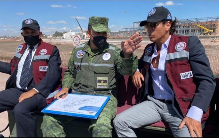 Roberto Palazuelos lleva una gorra y una chamarra color azul con letrero de 