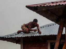 Un hombre asegura hoy el techo de su casa en  Bilwi, Puerto Cabezas, Nicaragua, previo al impacto de 