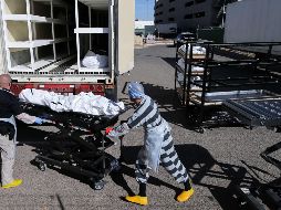Un preso trabaja en el traslado de cuerpos a un camión refrigerado instalado temporalmente afuera de la oficina forense de El Paso, en una imagen del 17 de noviembre. AFP/M. Tama