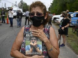 Una mujer se lamenta por la muerte de Maradona en las afueras de la casa del astro del futbol en Benavidez, en la provincia de Buenos Aires. AFP/J. Bromata
