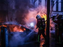 Bomberos extinguen el fuego tras los enfrentamientos en la capital francesa por la llamada ley de seguridad. EFE/M. Badra