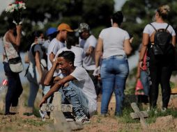 Una familia de venezolanos llora la muerte de su padre por coronavirus, durante el entierro en el cementerio de Caju en la zona norte de Río de Janeiro. EFE/A. Lacerda