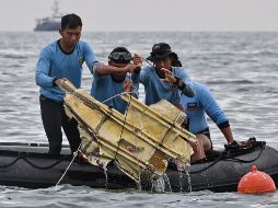 Buzos indonesios levantan hoy un trozo del avión Boeing localizado en el mar, cerca de la isla Lancang. AFP/A. Berry