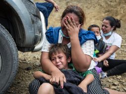 Una mujer migrante llora junto a su hijo luego que la Policía disolviera la caravana que bloqueba la carretera de Vado Hondo. EFE/E. Biba