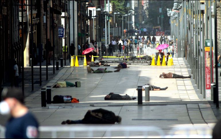 En las fotografías se observa a un grupo grande de personas recostadas en el suelo de las calles del centro de la Ciudad de México. TWITTER / @OnTheRedCarpet