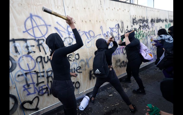 Manifestantes golpean las protecciones de madera alrededor del Monumento a la Revolución. AP/R. Blackwell