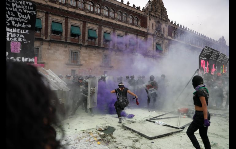 Policías repelen a encapuchadas que intentan cruzar por donde las vallas fueron derribadas. AP/R. Blackwell