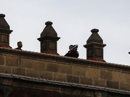 Se captó a un grupo de hombres en la azotea de Palacio Nacional, a quienes se les ve portando un objeto similar a un arma de fuego. SUN / D. Sánchez