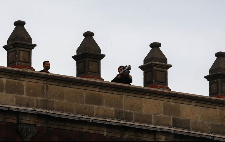 Se captó a un grupo de hombres en la azotea de Palacio Nacional, a quienes se les ve portando un objeto similar a un arma de fuego. SUN / D. Sánchez