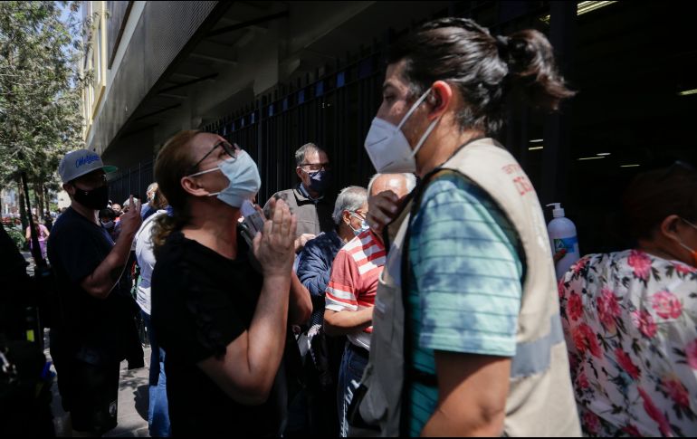 Súplicas. Adultos mayores que se quedaron al final de la línea ruegan a quienes están en el área logística del Centro Cultural El Refugio que se les aplique la vacuna, pues llevan muchas horas esperando. EL INFORMADOR / F. Atilano