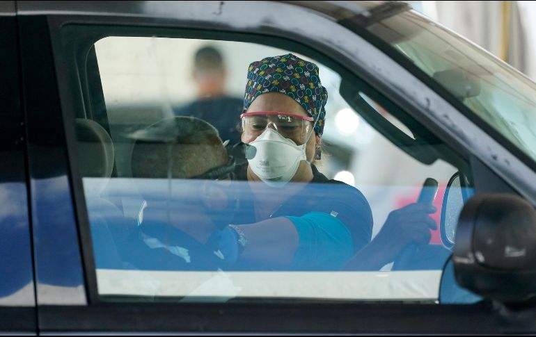 Una trabajadora del sector salud aplica una vacuna a un conductor en Miami. Estados Unidos  ya ha superado las 113 millones de dosis de las vacunas de la covid-19 administradas. AP/W. Lee