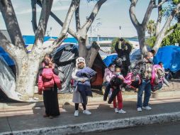 Un grupo de niños observa a migrantes que protestan en un campamento instalado en las inmediaciones del puerto fronterizo del Chaparral, en Tijuana. EFE/J. Terríquez