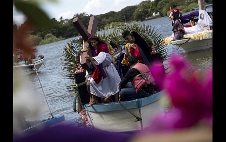 Decenas de personas ataviadas con tradicionales vestimentas católicas llenan de color las aguas del lago en esta solemnidad religiosa. EFE/J. Torres