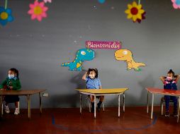 REGRESO. Estudiantes asisten a su primer día del clases semi-presenciales en la ciudades salvadoreñas. EFE