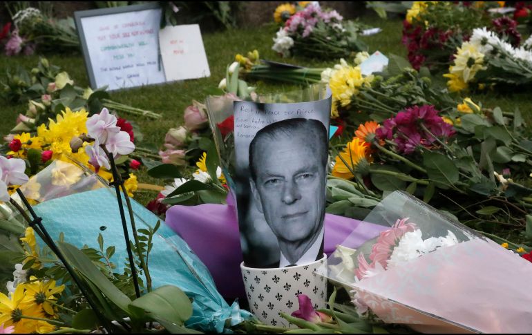 Algunas ofrendas florales son colocadas fuera del castillo de Windsor, junto a un retrato del duque de Edimburgo. AP / F. Augstein