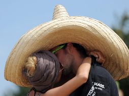 Una pareja se besa bajo un enorme sombrero en el Festival de Greenville en Paaren im Glien, en el norte de Alemania, el 28 de julio de 2013. AFP / ARCHIVO