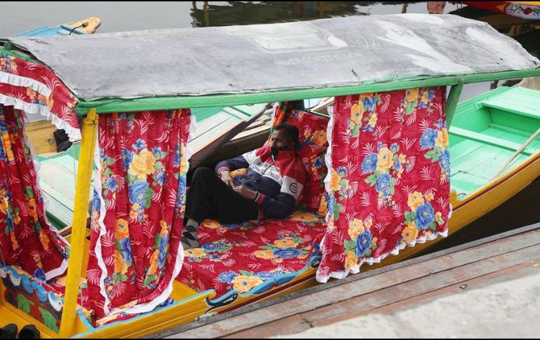 Un barquero de Cachemira descansa dentro de su bote durante el confinamiento a causa del nuevo coronavirus, en Srinagar. EFE