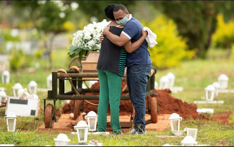 Un grupo de personas asiste al entierro de un ser querido víctima de COVID-19 en el cementerio Campo da Esperança, en la ciudad de Brasilia. EFE/J. Alves