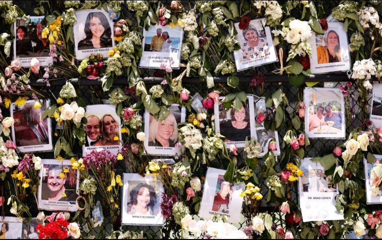 Fotos de personas desaparecidas se ven junto a un memorial improvisado en las inmediaciones del edificio colapsado en Surfside, Florida. Aún hay 126 personas desaparecidas. AFP/M. Reaves