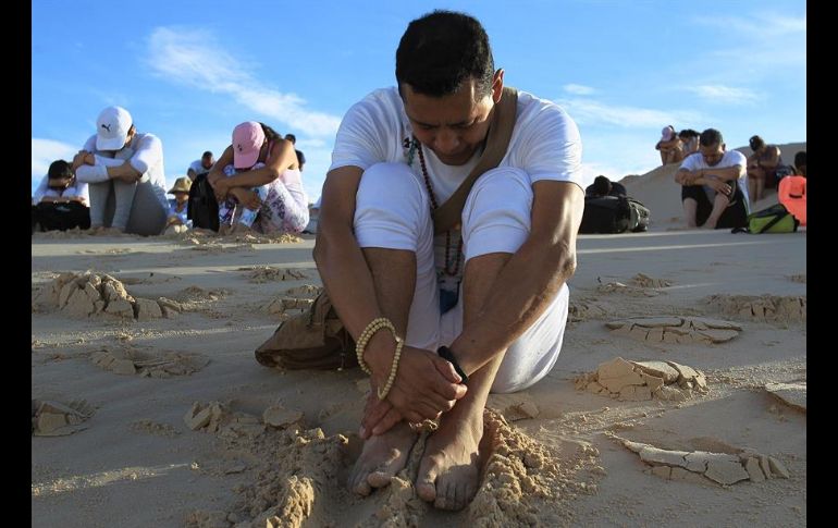 Los deportistas estaban vestidos de blanco y sus pies tenían contacto con la fina arena de la región desértica. EFE/L. Torres