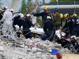 Rescatistas trasladan un cuerpo hallado hoy entre los escombros del edificio en Surfsine. AP/L. SladkySladky