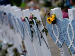 Flores y mensajes adornan estructuras de madera colocadas en honor de las víctimas cerca del edificio colapsado en Surfside, Florida. AP/R. Blackwell