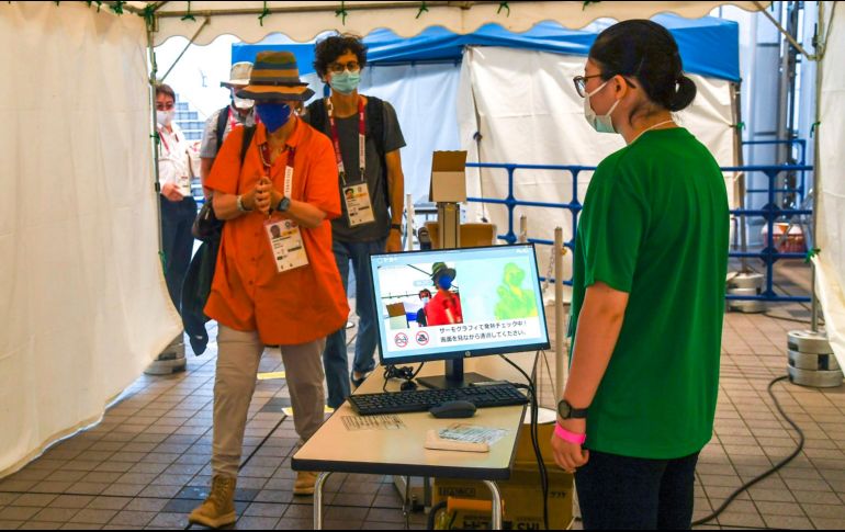 Periodistas se toman la temperatura antes de entrar al Centro Principal de Prensa de Tokio 2020. EFE / C. Fusco