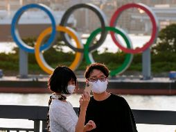 Japoneses se toman una fotografía frente el Monumento de los anillos olímpicos en Odaiba. EFE / K. Mayama
