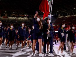 Se observa a los atletas de México grabando con su celular, otros gritan, saludan y brincan conforme avanzan en el desfile. Algunos traen una pequeña bandera del país. AFP / O. Andersen
