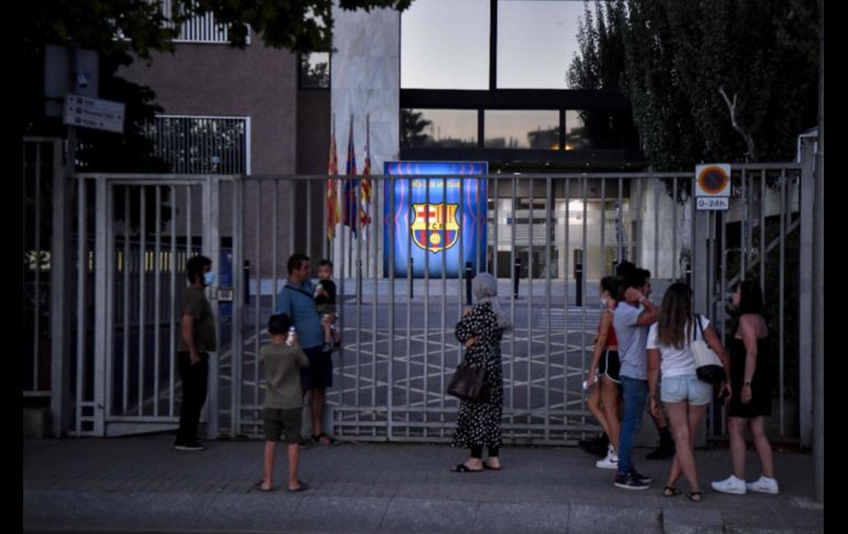 Aficionados se asomaban por las entradas a la Ciudad Deportiva del Barcelona en busca de alguien que les diera explicaciones. AFP/P. BARRENA