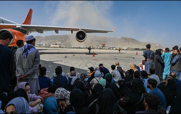 Afganos permanecen en el aeropuerto de Kabul. AFP / W. Kohsar