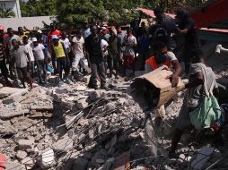 Un grupo de personas remueve escombros en una calle de Los Cayos. EFE/O. Barría