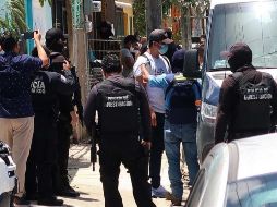 Agentes de la Policía Ministerial de la Fiscalía General Estatal escoltan a un grupo de migrantes asegurados en una casa de la ciudad de Cancún. EFE/A. Cupul