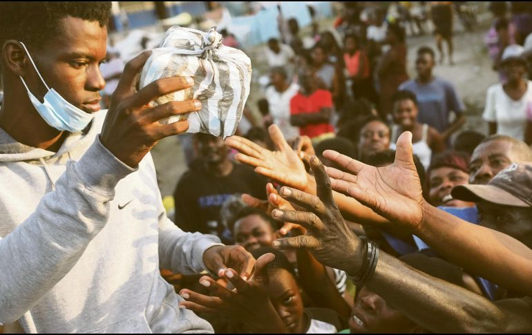 Hambre. Miles de haitianos esperan la ayuda humanitaria para abastecer a sus familias, luego de perderlo todo durante el sismo de la semana pasada. AP