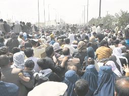 Miles de personas esperan la oportunidad de abordar un avión para salir de Afganistán, tras la llegada del régimen Talibán. AFP/W. Kohsar