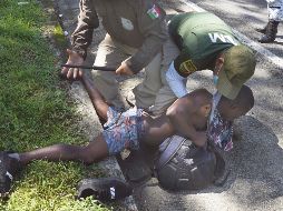 CONTIENEN CARAVANA. Agentes de inmigración mexicanos detienen a un migrante haitiano en Escuintla, estado de Chiapas, México. AP