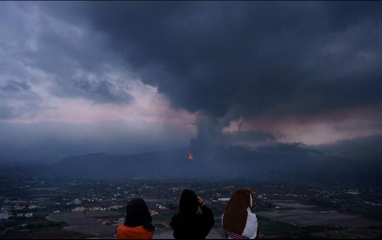 Unas niñas buscan con prismáticos su vivienda en el barrio de El Paraíso, una de las zonas más afectadas por la erupción que tiene lugar en la isla de La Palma. EFE/R. de la Rocha