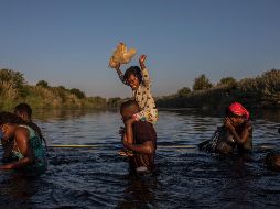 Un grupo de migrantes haitianos cruzan el Río Bravo para regresar a Ciudad Acuña, donde esperan mientras logran cruzar a los Estados Unidos. AP / F. Márquez